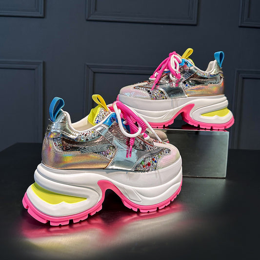These chunky platform sneakers feature a dazzling holographic silver upper, vibrant pink laces, and a bold white and pink platform sole. Make a statement with these trendy fashion sneakers.Shop now!