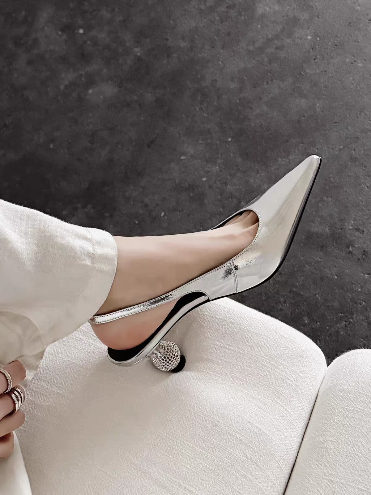Silver metallic pointed-toe slingback shoe with crystal ball heel