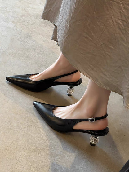 Black pointed-toe slingback shoes with crystal ball heels