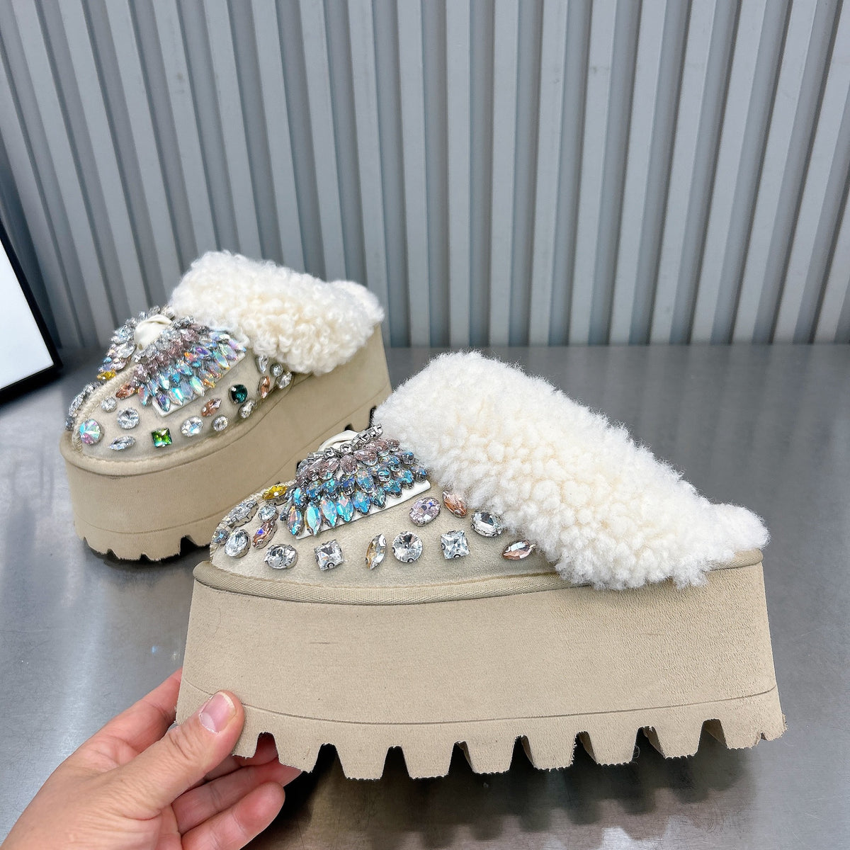 Close-up of beige rhinestone embellished backless platform mules with plush faux fur lining