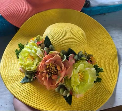 Yellow wide-brim straw sun hat with peach and pale yellow flowers