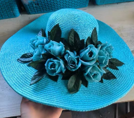 Turquoise straw sun hat with matching blue floral decoration