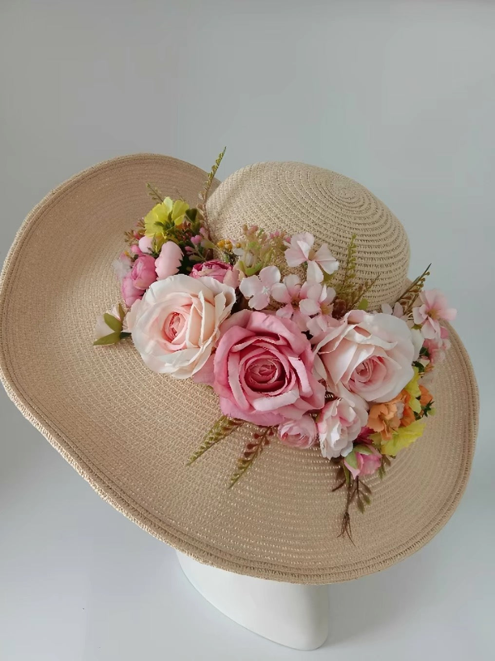 Beige wide-brim straw sun hat decorated with pink and ivory roses