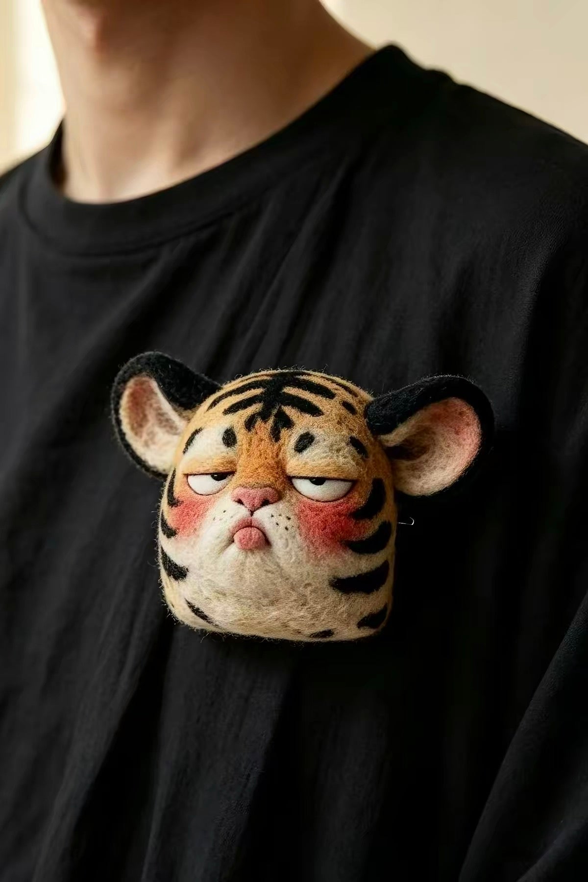 Handmade felt tiger face brooch with black stripes and rosy cheeks
