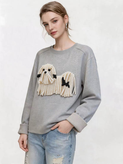Model wearing the grey sweatshirt with pearl dog embellishment and turned-back cuffs