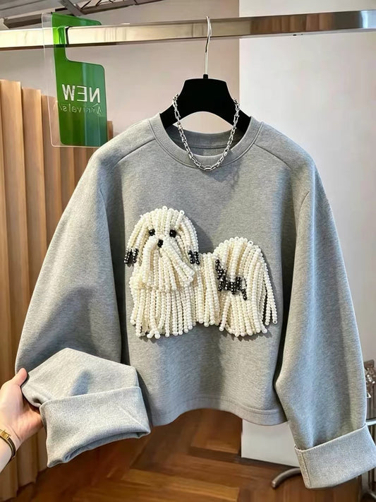 Grey sweatshirt featuring a white pearl-beaded dog design with black details