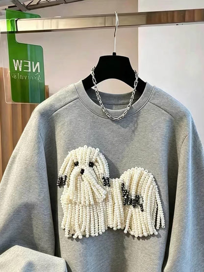 Close-up of the pearl-beaded dog embellishment on the grey sweatshirt