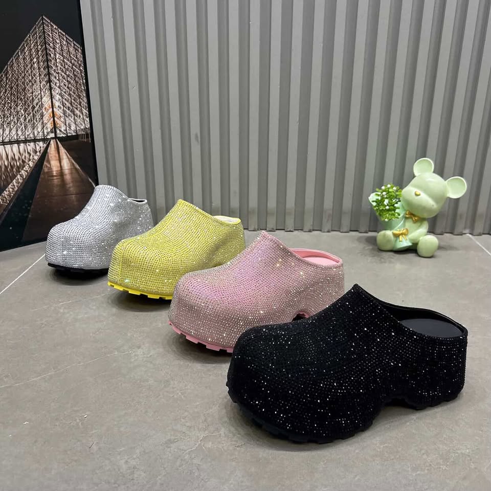 Four glittery clogs in black, pink, yellow, and silver 