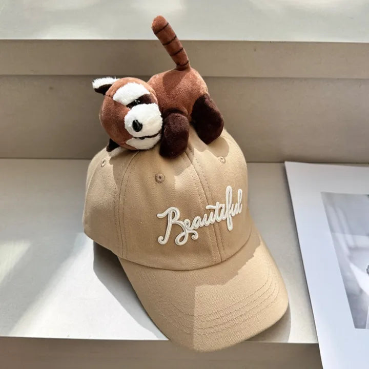 Beige baseball cap with plush animal topper