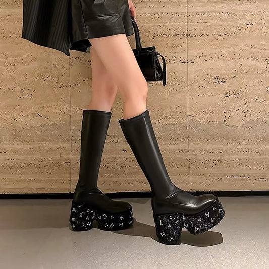 Black genuine leather knee-high platform boots with chunky embellished wedge soles and tall shaft