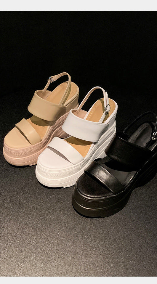 Three sandals in black, white, and beige on a dark background