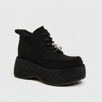 Black platform boot with rhinestone details on a white background